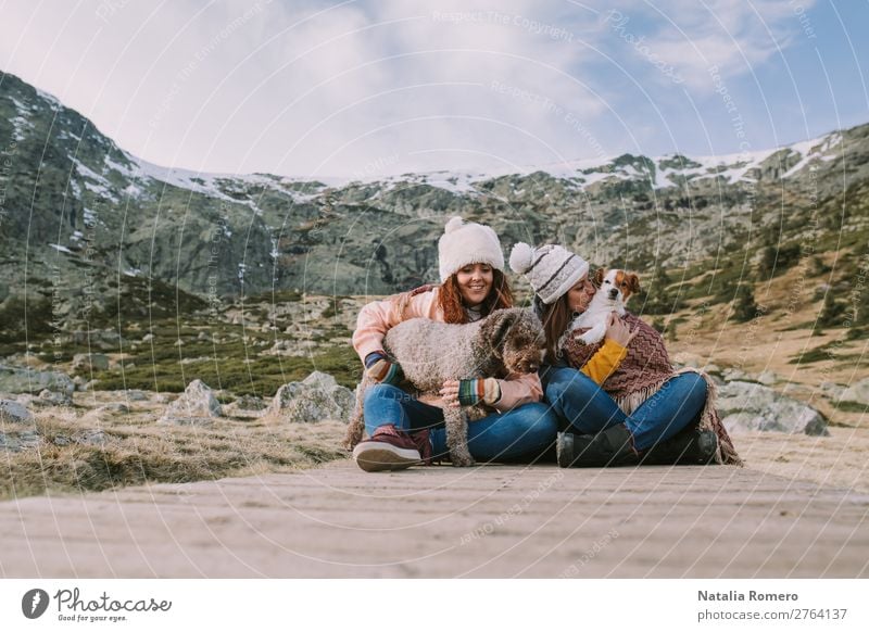 two friends play with their dogs sitting in the meadow Lifestyle Style Joy Happy Beautiful Leisure and hobbies Playing Adventure Mountain Sports Woman Adults