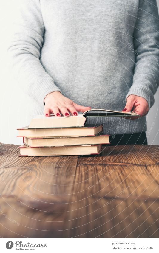 Young woman looking at pages of book on table in bookstore Lifestyle Shopping Relaxation Leisure and hobbies Reading School Study Human being Woman Adults