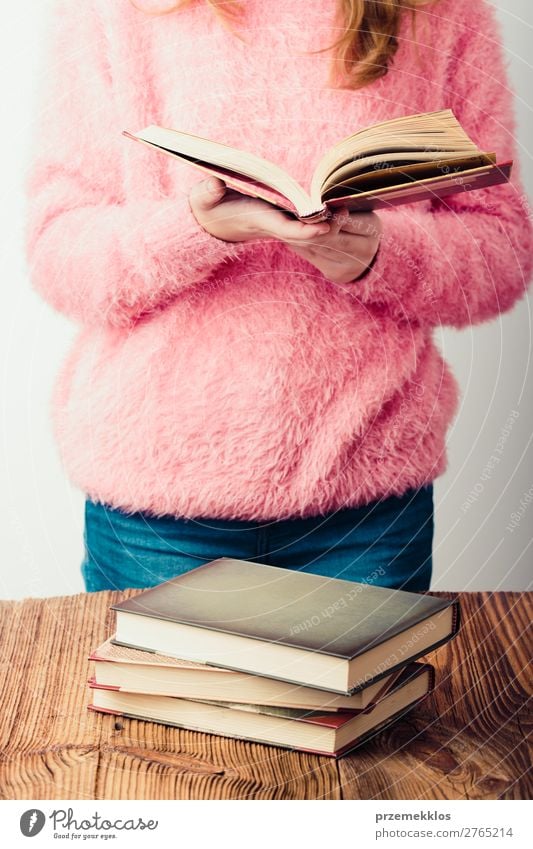 Young girl holding a book standing in bookstore Lifestyle Relaxation Leisure and hobbies Reading School Study Human being Woman Adults Youth (Young adults) 1