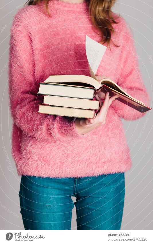 Young girl holding a few books Lifestyle Relaxation Leisure and hobbies Reading School Study Human being Woman Adults Youth (Young adults) 1 Book Library