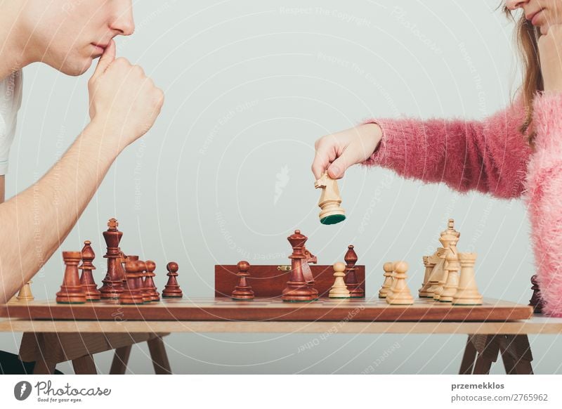 Girl and boy playing chess at home. Girl moving her piece Lifestyle Leisure and hobbies Playing Chess Success Human being Boy (child) Woman Adults Man To enjoy