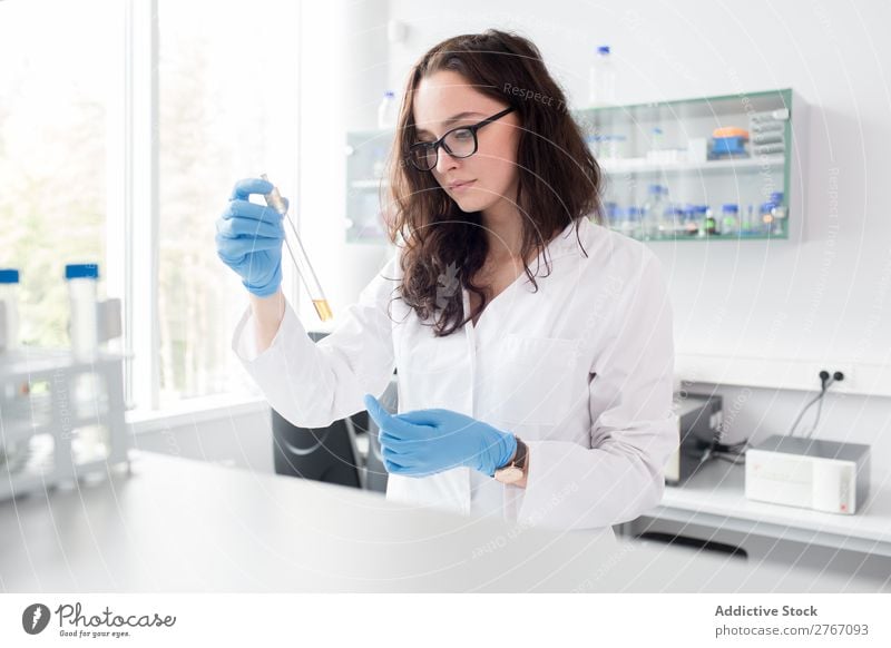 Woman looking at test tube Laboratory Work and employment Science & Research Test tube Reaction Observe Human being Scientist Medication Chemistry Technology