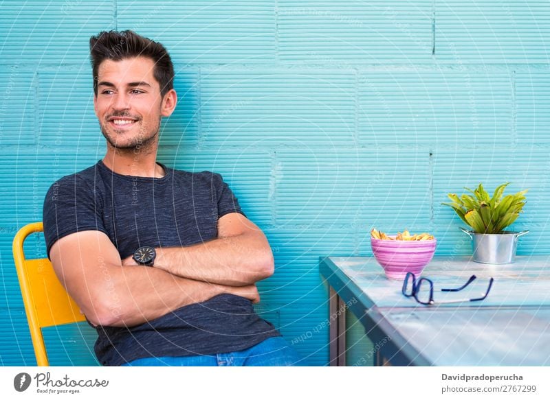 Happy young man seating in a restaurant Adults Loneliness Attractive Beautiful Blue Bright Caucasian Coffee Café Multicoloured enjoying Food Fries Guy handsome