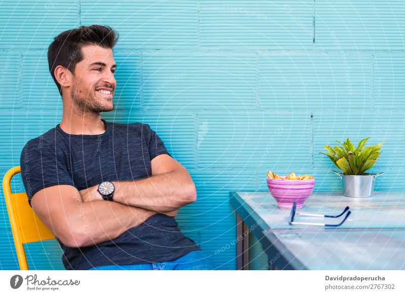 Happy young man seating in a restaurant Adults Loneliness Attractive Beautiful Blue Bright Caucasian Coffee Café Multicoloured enjoying Food Fries Guy handsome