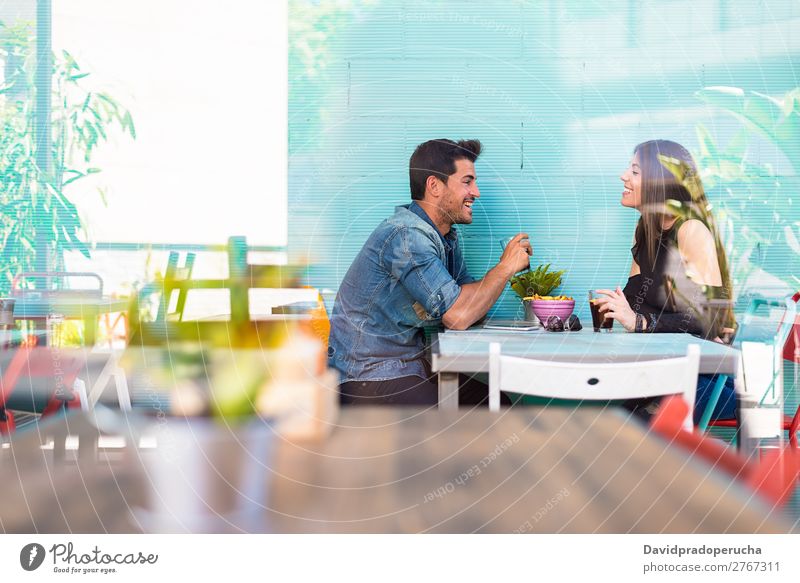 Happy young couple seating in a restaurant Adults Attractive Background picture Beautiful Blue Caucasian Coffee Cola Multicoloured Couple Drinking enjoying