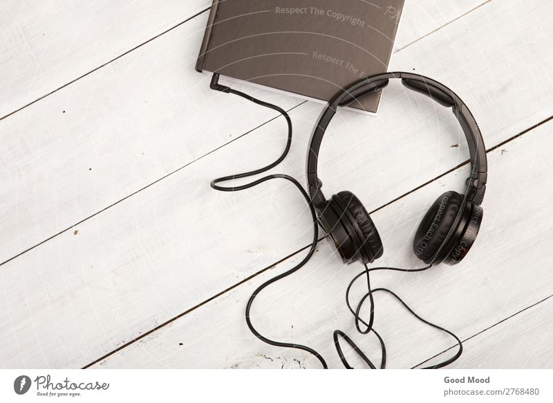 Audio book concept with black book and headphones Leisure and hobbies Playing Reading Music School Study Headset Technology Media Book Library Paper Wood