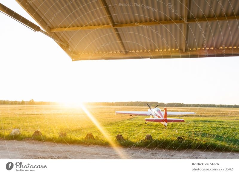 Shiny red airplane in green field Airplane Airfield Summer Transport Vacation & Travel Story Sunlight aerodrome Tourism Trip Glittering Technology Departure