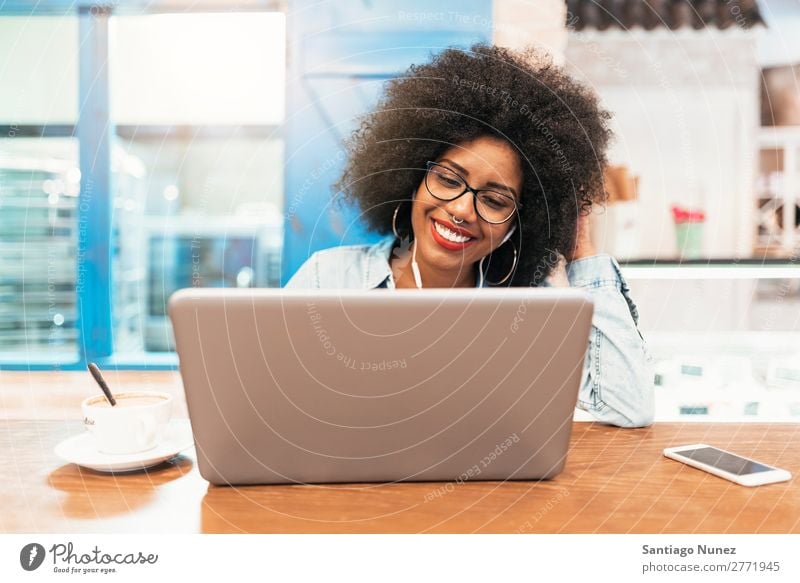 Beautiful afro american woman using mobile and laptop in the coffee shop. Communication concept. Woman Black African Afro Business Coffee Businesswoman