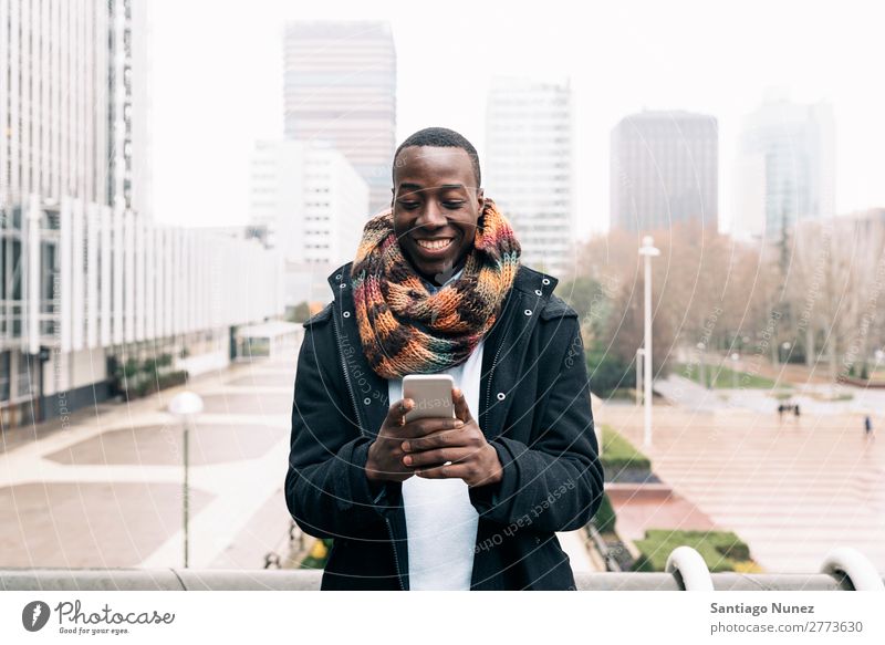 Businessman in the Street. Man Black African American Cellphone Youth (Young adults) Telephone Happy Mobile Exterior shot PDA texting Communication Typing