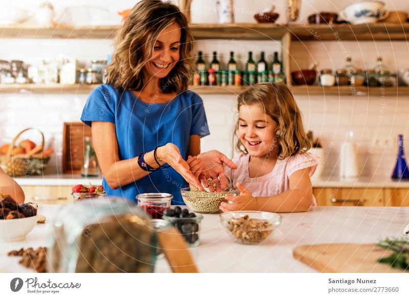 Little sisters cooking with her mother in the kitchen. Mother Girl Cooking Kitchen Buckwheat Water Ice cream Daughter Day Happy Joy Family & Relations Love