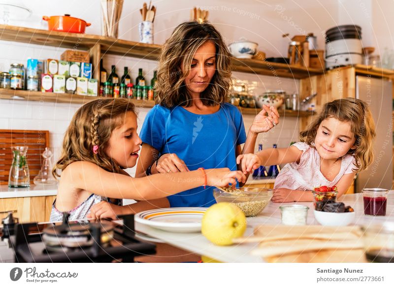 Little sisters cooking with her mother in the kitchen. Mother Child Girl Cooking Kitchen Chocolate Ice cream Daughter Day Happy Joy Family & Relations Love