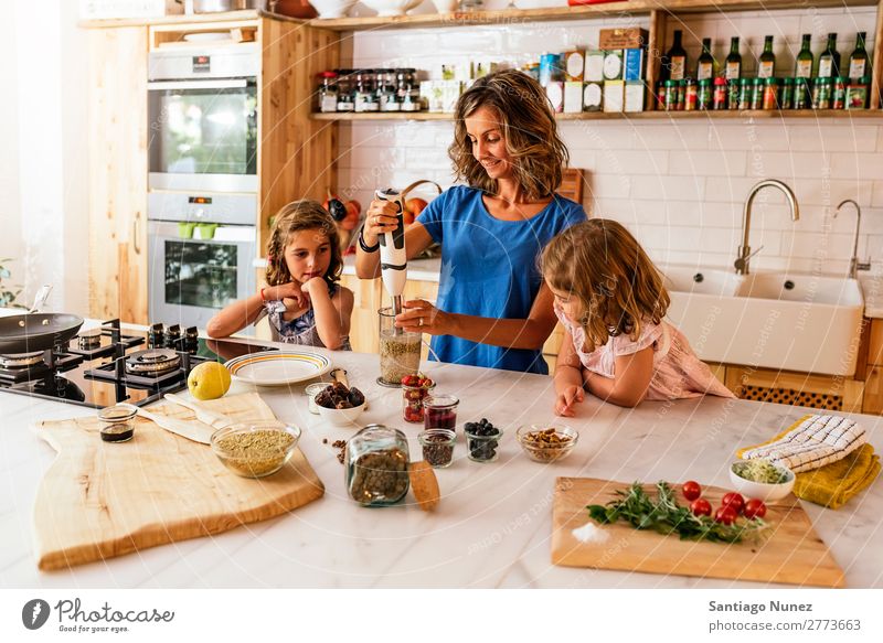 Little sisters cooking with her mother in the kitchen. Mother Child Girl Cooking Kitchen Mixer Tomato Pizza Vegetable Daughter Spread Day Happy Joy