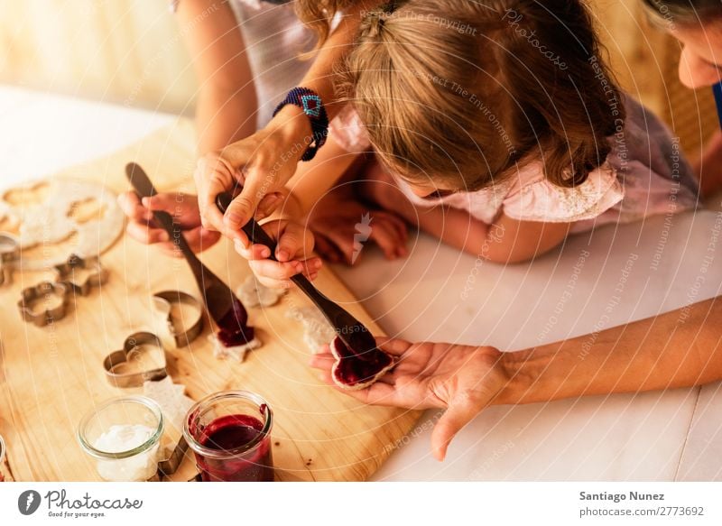 Little sisters cooking with her mother in the kitchen. Mother Child Girl Cooking Kitchen Chocolate Jam Strawberry Daughter Spread Day Happy Joy