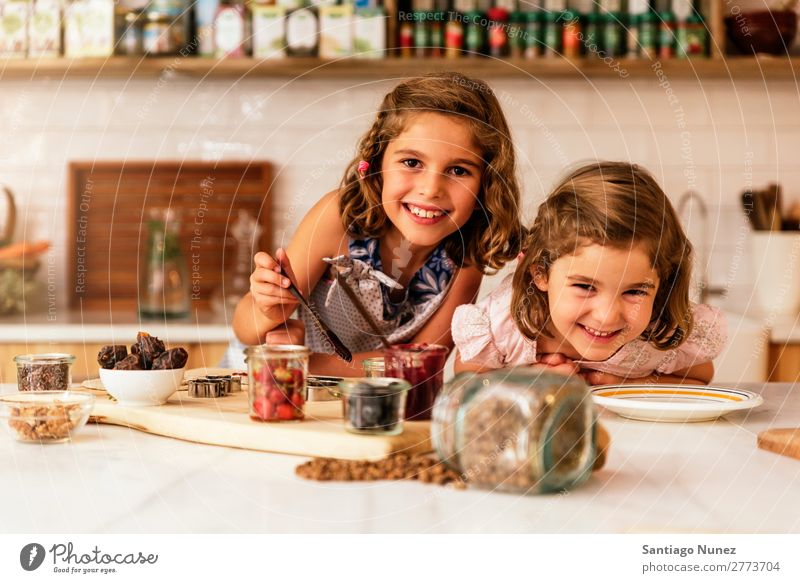 Little sisters girl preparing baking cookies. Child Girl Cooking Kitchen Chocolate Flour Dirty stained Laughter Daughter Day Happy Joy Playing