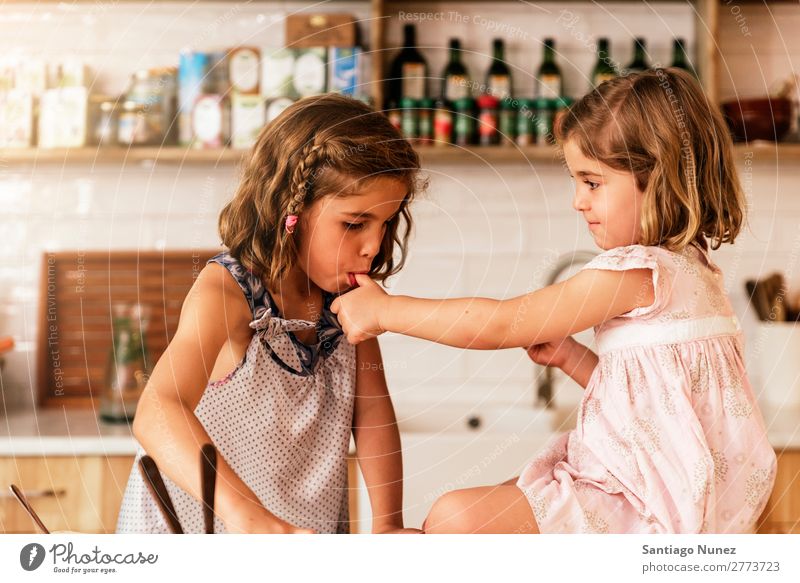 Little sisters girl preparing baking cookies. Child Girl Cooking Kitchen Chocolate tasting savoring Fingers Ice cream Strawberry Daughter Day Happy Joy