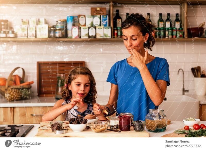 Little girl cooking with her mother in the kitchen. Mother Girl Cooking Kitchen Chocolate tasting savoring Daughter Day Happy Joy Family & Relations Love Baking