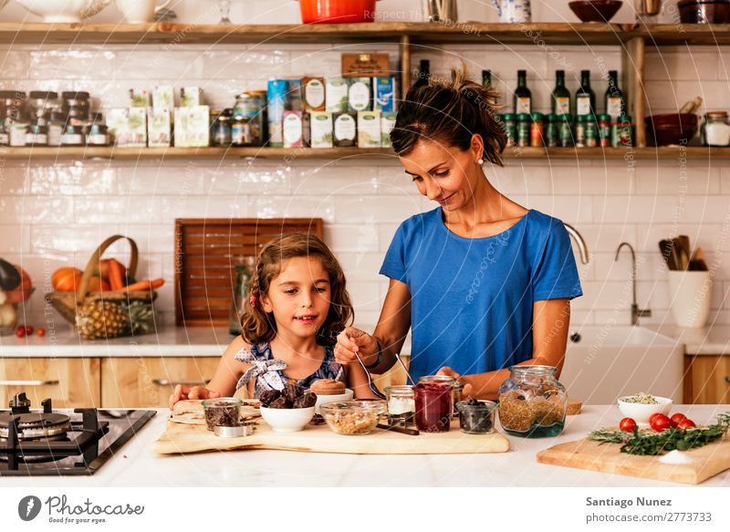 Little girl cooking with her mother in the kitchen. Mother Girl Cooking Kitchen Chocolate Ice cream Daughter Day Happy Joy Family & Relations Love Baking Food