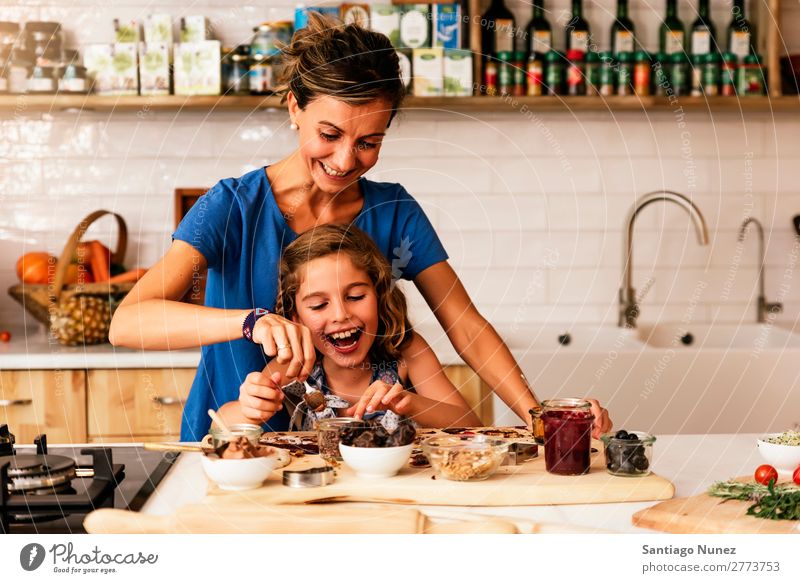 Little girl cooking with her mother in the kitchen. Mother Girl Cooking Kitchen Chocolate Ice cream Daughter Day Happy Joy Family & Relations Love Baking Food