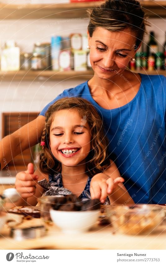 Little girl cooking with her mother in the kitchen. Mother Girl Cooking Kitchen Chocolate Ice cream Daughter Day Happy Joy Family & Relations Love Baking Food