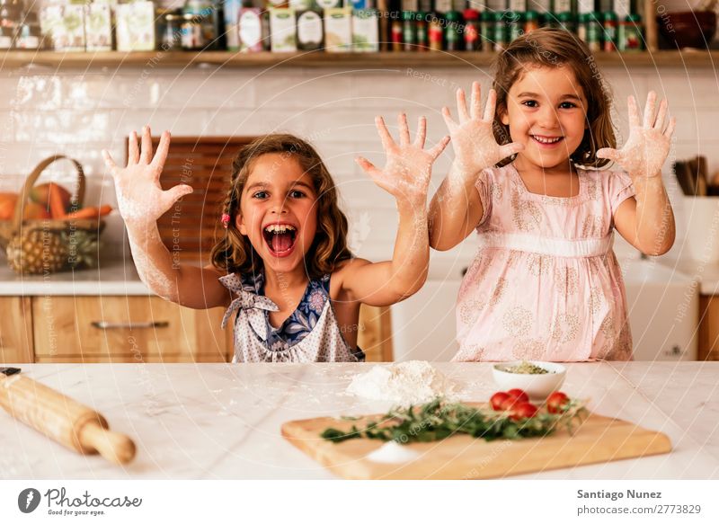 Little sisters girl preparing baking cookies. Child Girl Cooking Kitchen Chocolate Flour Hand Dirty stained Laughter Daughter Day Happy Joy Playing