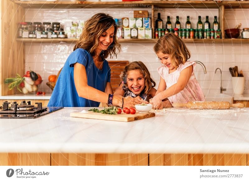 Little sisters cooking with her mother in the kitchen. Mother Child Girl Cooking Kitchen Crêpe Pizza Vegetable Daughter Spread Day Happy Joy Family & Relations