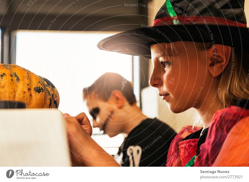 Happy children disguised decorating a pumpkin at home. Hallowe'en Child Girl Boy (child) Painting (action, artwork) Skeleton Witch Joy Family & Relations Sister