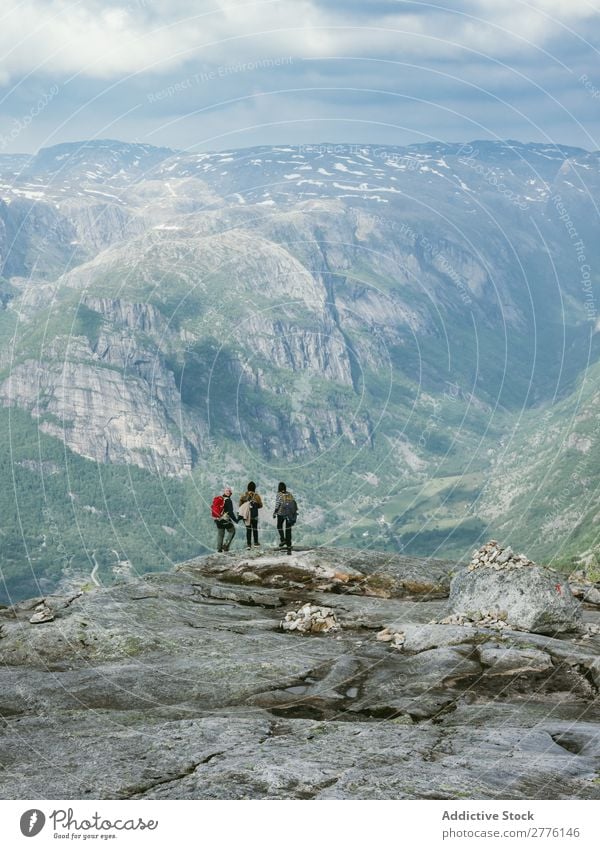 Tourists on background of mountains Human being tourists Mountain Cliff trekking tranquil Hiking Nature backpackers exploration Group Vacation & Travel