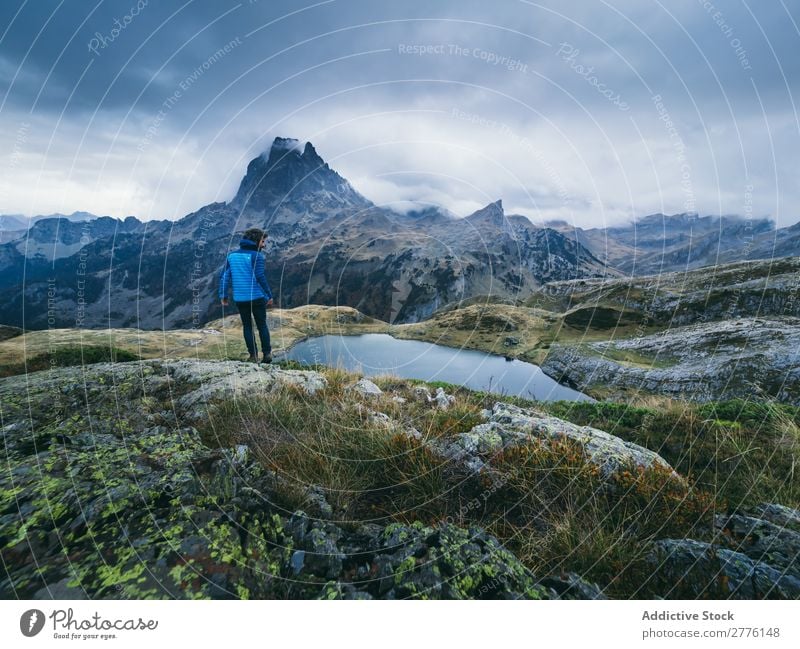 Traveler posing alone in mountains Human being traveler Clouds Mountain Dream Range Panorama (Format) tranquil Nature Lake Mysterious exploration