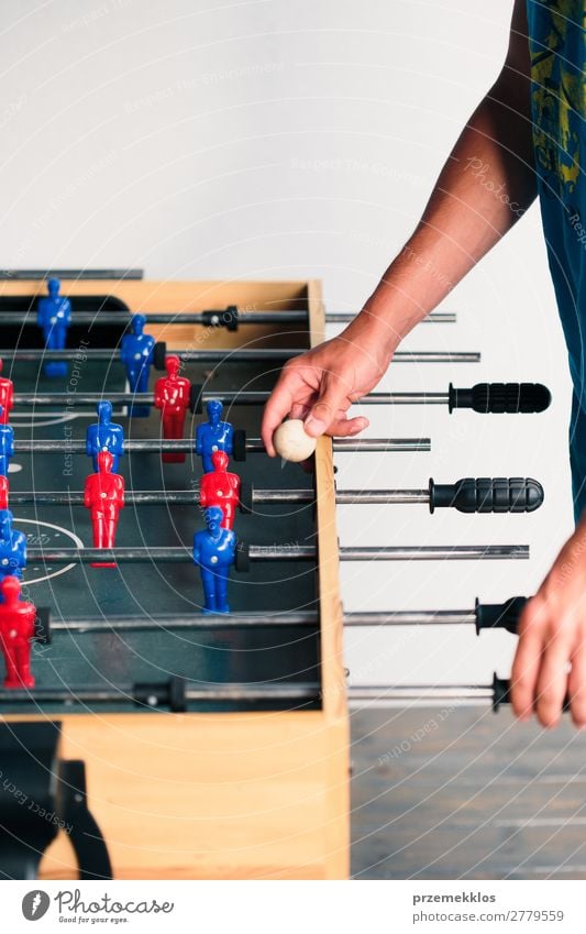 Young teenager boy playing table football with another player. Lifestyle Joy Relaxation Leisure and hobbies Playing Summer Table Sports Soccer Boy (child) Man