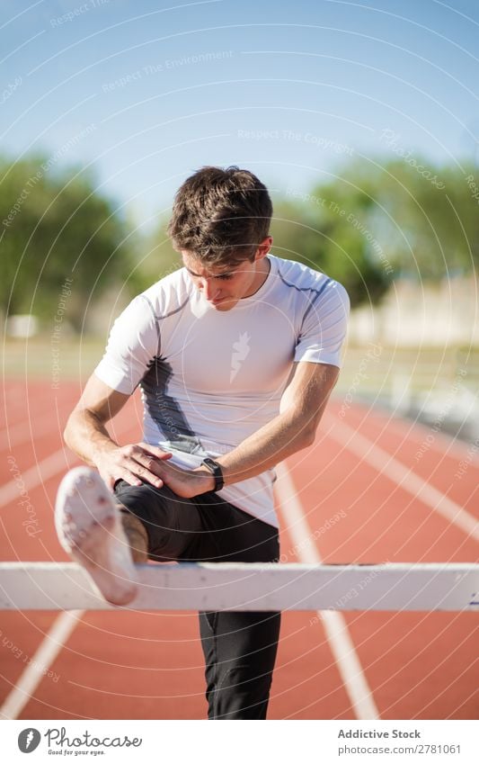 Young sportsman stretching legs Man Stretching Stadium Posture Flexible Fitness Practice Athlete Sports Muscular Health care Adults Sprinter Athletic