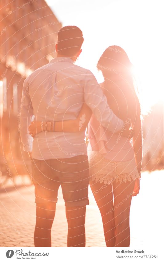 Unrecognizable hugging couple in sunny street Couple Embrace Street Rear view Sunlight Bright Walking Stand Observe Vertical Stern Blur Sunbeam Brunette