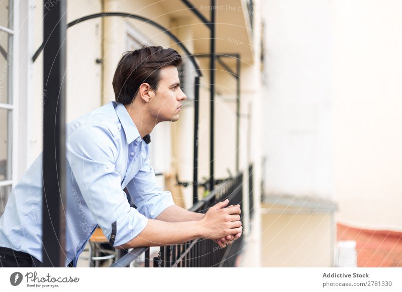 Young serious man in blue shirt posing Man Earnest Stand Balcony Portrait photograph Gesture Considerate Pensive Posture Human being 1 Youth (Young adults)