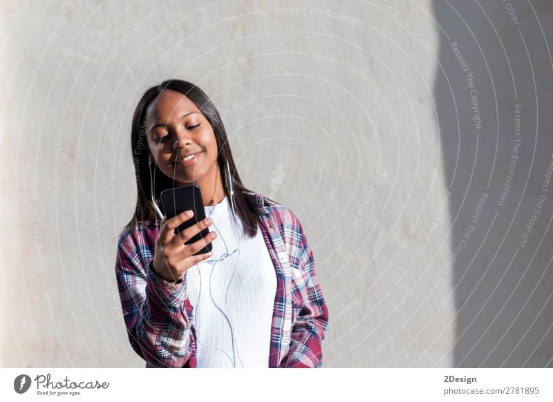 Front view of a young smiling african american woman standing Lifestyle Happy Beautiful Entertainment Music Telephone Human being Feminine Young woman