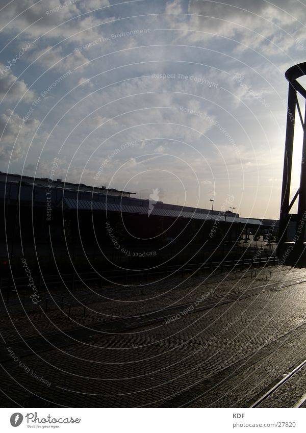 Sunset in the industrial area Wisp of cloud Cobblestones Paving stone Factory Industrial plant Factory hall Sky Railroad tracks Wholesale market Back-light