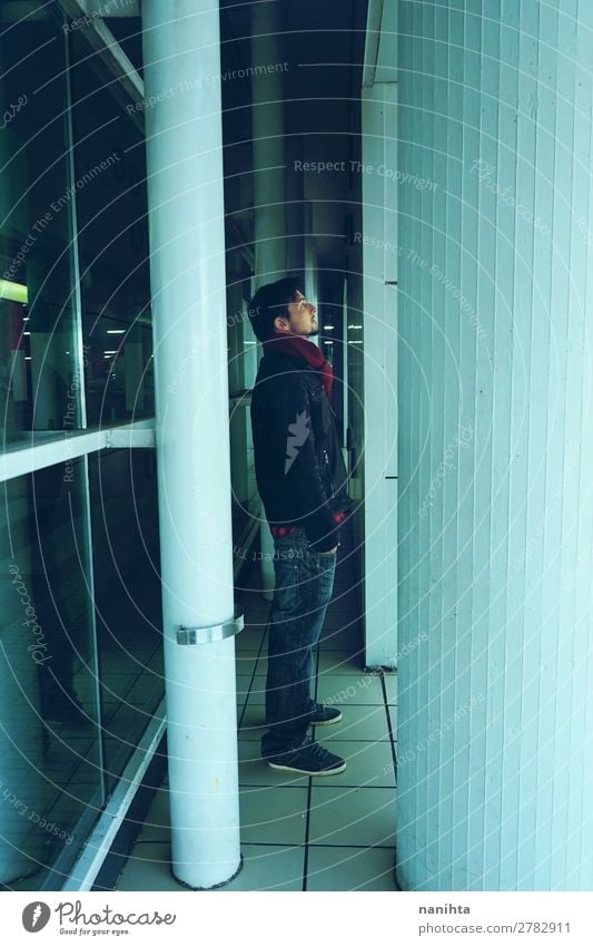 Young man alone in a bus station at night Lifestyle Winter Mirror Human being Masculine Youth (Young adults) Man Adults Sadness Town Blue Hope Loneliness