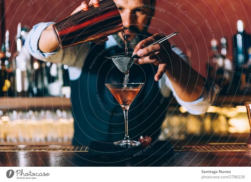 Barman is making cocktail at night club. Cocktail shaker barman bartender Waiter Man Stir mixologist adding Alcoholic drinks Business Club Drinking Bottle