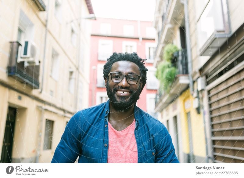 Young african man in the street. Man African Lifestyle Listening Black American Town Portrait photograph handsome Stand Hipster Dreadlocks Busker