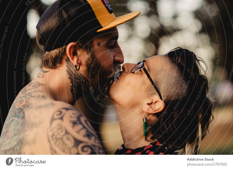 Young guy in tattoos hugging lady in forest Couple Tattoo Embrace Forest snapback Park Lady shirtless Guy Youth (Young adults) Hipster embracing Man Woman