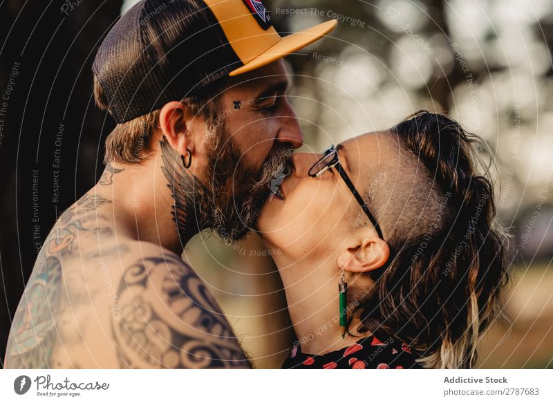 Young guy in tattoos hugging lady in forest Couple Tattoo Embrace Forest snapback Park Lady shirtless Guy Youth (Young adults) Hipster embracing Man Woman