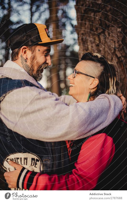 Happy couple hugging and kissing near tree in park Couple Embrace Park Tree embracing Back Wood Forest Youth (Young adults) Cheerful bearded Man Woman Joy