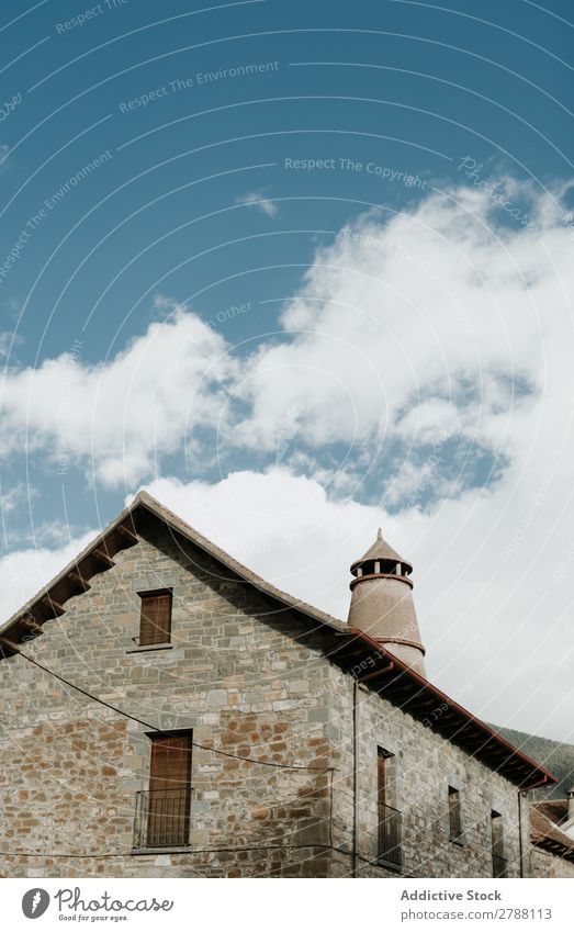 Tower near brick building and cloudy sky Brick Building Sky Pyrenees Clouds Construction Heaven Blue Height Facade Weather Beautiful Architecture Roof Exterior