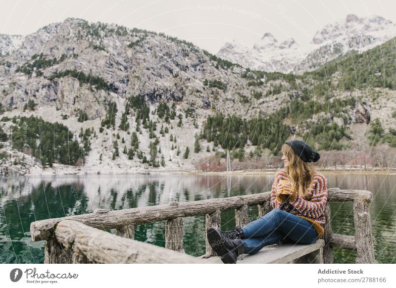 Woman on seat near wonderful lake between hills in snow Lake Hill Seat Snow Pyrenees Wonderful Water Surface Mountain Lady Height Tree Amazing Bench