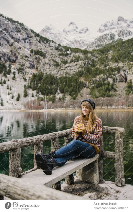 Woman on seat near wonderful lake between hills in snow Lake Hill Seat Snow Pyrenees Wonderful Water Surface Mountain Lady Height Tree Amazing Bench