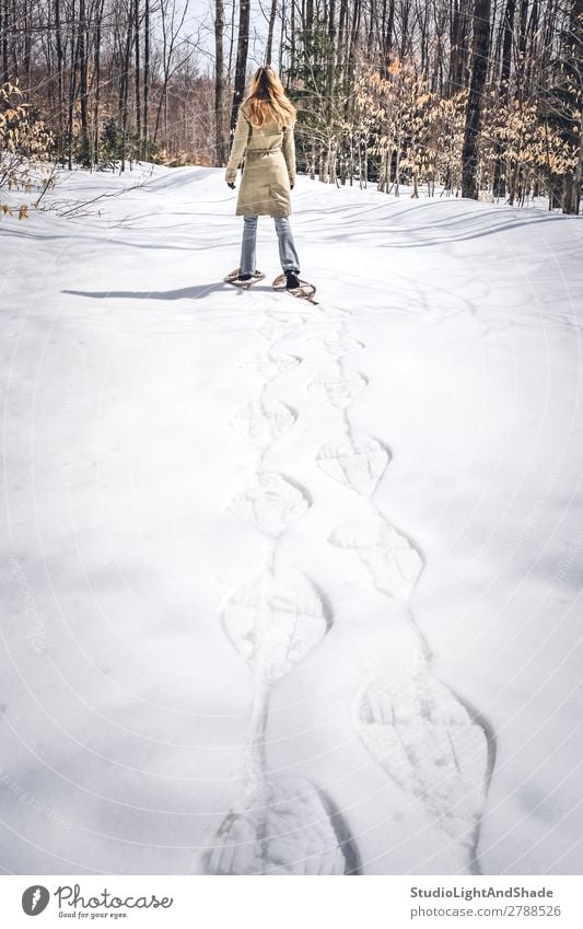 Young woman in snow shoes walking in winter forest Lifestyle Relaxation Leisure and hobbies Adventure Winter Snow Hiking Sports Human being Woman Adults Forest