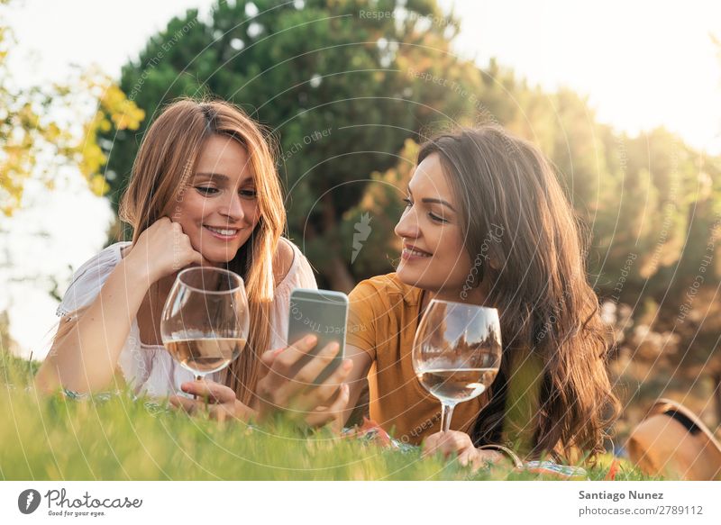 Beautiful women using mobile in the park. Woman Picnic Friendship Youth (Young adults) Park Happy Summer Human being Joy Mobile PDA Telephone Solar cell texting