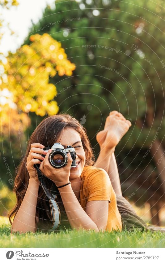 Smiling young woman using a camera to take photo at the park. Photographer Woman Photography Camera Youth (Young adults) Girl Digital White Leisure and hobbies