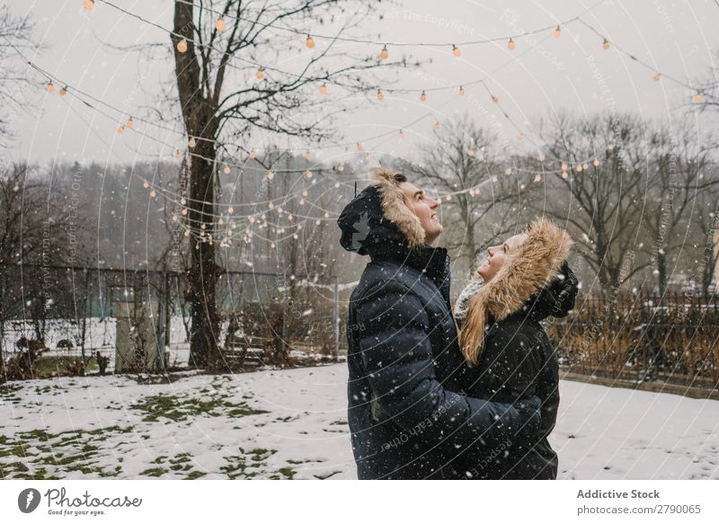 Smiling couple having fun on street near tree with fairy lights Couple Fairy lights Christmas & Advent Street Tree Guy Lady ski jacket Happy Hand Wood