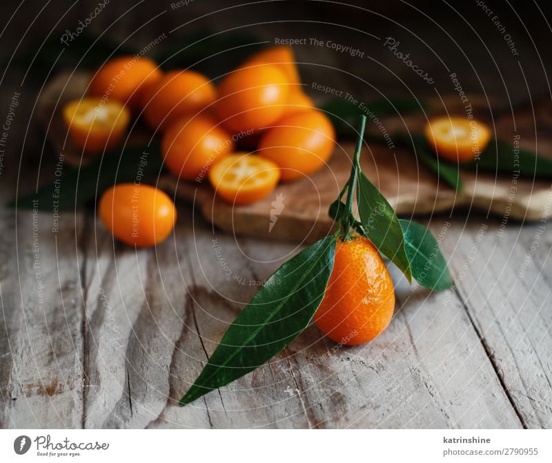 Kumquat fruits on a wooden background Fruit Dessert Nutrition Vegetarian diet Diet Exotic Group Leaf Fresh Natural Juicy Yellow Gray Colour citrus cumquat