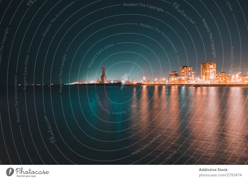 Calm sea near illuminated night city Ocean City coastal Night Illumination Water Surface The Arctic Vacation & Travel Trip Tourism Deserted Evening Sky Building