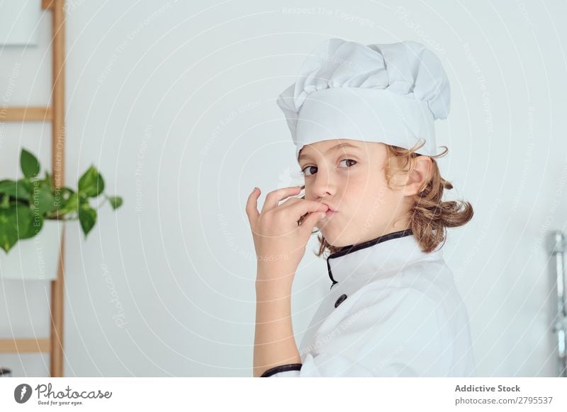 Boy in cook hat showing delicious gesture in kitchen Cook Boy (child) Kitchen Delicious chef Child Hat Cool (slang) Gesture Cooking Modern Home Gourmet Indicate